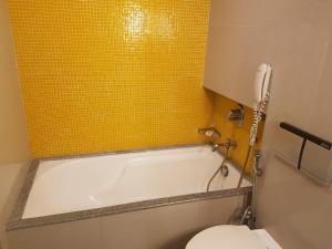 孟买拉米盖斯特林达德拉酒店的浴室配有白色浴缸和卫生间。