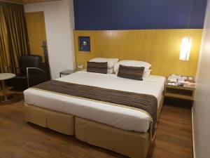 孟买拉米盖斯特林达德拉酒店的一间位于酒店客房内的带大床的卧室