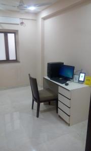 加尔各答Treebo Trend Vedanta的办公室配有带笔记本电脑和椅子的书桌