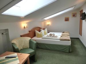 米滕瓦尔德卡尔尼龙堡酒店的一间卧室配有一张床、一把椅子和一张桌子