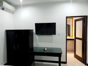 努沙杜瓦棕榈竹酒店的一间设有桌子的房间和墙上的电视