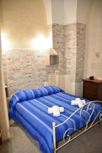阿韦特拉纳Cala del Conte b&b的一间卧室配有蓝色的床和毛巾