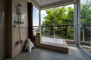 读谷村E-horizon Resort Condominium Yomitan的带淋浴和盥洗盆的浴室以及窗户。