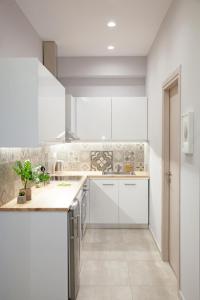 雅典Omnia Pagrati Apartments的厨房配有白色橱柜和台面