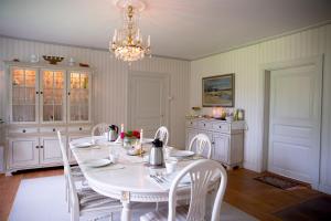 法伦Olsbacka Gård的一间配备有白色桌椅的用餐室