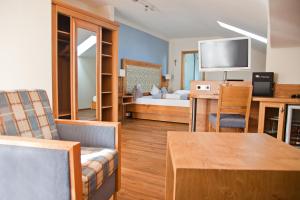 巴特科尔格鲁布Hotel am Wiesenhang - Garni的客厅设有一间卧室,配有一张床和一张桌子