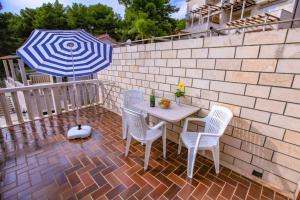 苏曼婷Villa Pinus的庭院内桌椅和遮阳伞