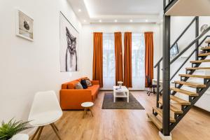 布达佩斯Hello Downtown Apartment - Boulevard的客厅配有橙色沙发和楼梯