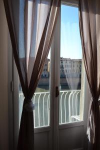 比萨你与我旅馆的窗户配有窗帘,享有阳台的景致。