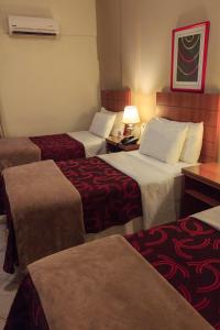 埃斯特城康维尔酒店的酒店客房,设有三张床和一盏灯