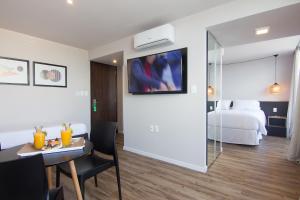 蒙得维的亚Hotel Ciudadano Suites的酒店客房,配有一张床铺和一张桌子,还有一间客房