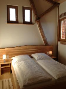 Neuburg-SteinhausenGästehaus Landgut Lischow的卧室内的一张床位,设有两个窗户