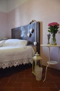 阿雷佐乡村山乡村民宿的一间卧室配有一张床和一张鲜花桌