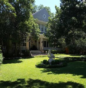 奥斯汀Strickland Arms Bed and Breakfast的院子里有熊雕像的房子