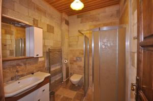 格雷梅卡帕多西亚石宫酒店的带淋浴、盥洗盆和卫生间的浴室