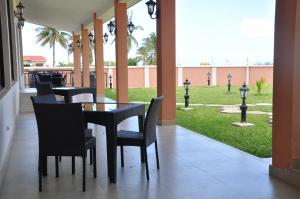 姆特瓦拉Luwa Evergreen Hotel的一间带桌椅的用餐室和草坪