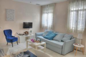 塞维利亚SEVILLA BUTTERFLY SUITES的客厅配有蓝色的沙发和电视