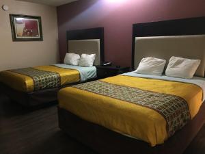 拉斐特Express Inn的酒店客房带两张带黄床单的床