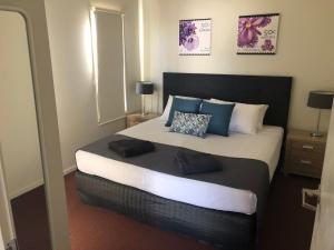 怀阿拉阳光庄园客栈&旅游假日公园的一间卧室配有一张大床和两个枕头