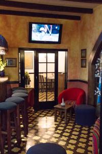 危地马拉老城酒店的酒吧配有椅子,墙上配有电视