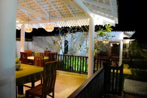 高尔Odailem Resort - Talpe的阳台餐厅配有桌椅