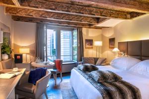 日内瓦Hôtel Les Armures的酒店客房设有一张大床和一张书桌。