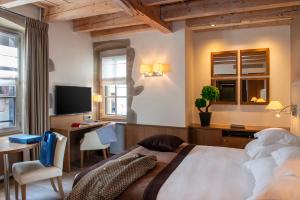 日内瓦Hôtel Les Armures的一间卧室配有一张床、一张书桌和一台电视