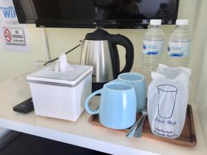 乔木提恩海滩泰国兰花经济型酒店的茶壶、咖啡壶和瓶装水