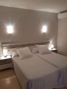 巴古尔Hostal Ondina的配有2盏灯的酒店客房的2张床