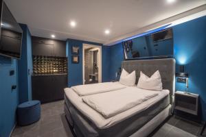 蒂宾根泽特瑞银穆海泽德爱特斯坦德公寓的一间拥有蓝色墙壁的卧室和一张带白色床单的床