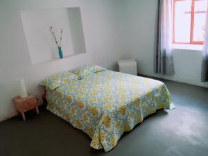 瓦拉斯Casa I Love Huaraz的一间卧室配有一张带黄色床罩的床和窗户