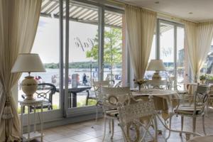 瓦伦Hotel Am Yachthafen的一间带桌椅和大窗户的用餐室