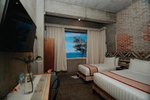 杜马格特砖头酒店的一间卧室设有两张床和一个海景窗户。