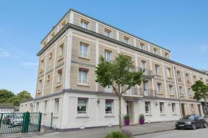 洛里昂Brit Hôtel Confort Cléria Lorient Centre的前面有一棵树的白色大建筑