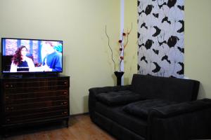 博尔若米Apartament GIORGI的带沙发的客厅和梳妆台上的电视