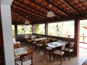 林多亚Pousada do Grande Lago的用餐室设有桌椅和窗户。