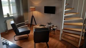 凯瑟尔Baron Frits的客厅配有两把椅子和电视