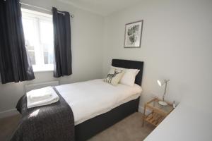 班伯里The Hanwell的一间卧室配有一张带白色床单的床和一扇窗户。