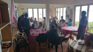 Comunidad YumaniHostal Inti Wayra的一群坐在房间里桌子的人