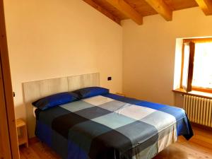 泰穆B&B Villa Dalegno的一间卧室配有一张带蓝色枕头的床和一扇窗户。