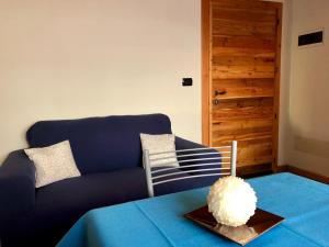 泰穆B&B Villa Dalegno的客厅配有蓝色的沙发和桌子
