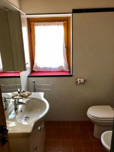 泰穆B&B Villa Dalegno的一间带水槽和卫生间的浴室以及窗户。