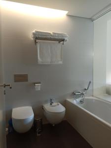 里斯本YingYing Apartamento with a free parking space的浴室配有卫生间、浴缸和水槽。
