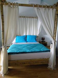 圣玛丽海伦娜住宿加早餐别墅 的一间卧室配有一张带蓝色床单和天蓬的床