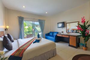 卡伦海滩Kasemsuk Guesthouse SHA Extra plus的配有一张大床和镜子的酒店客房