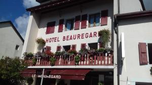 迪沃讷莱班Hotel Le Beauregard的酒店大楼内的阳台种有植物