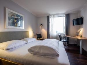 Menzberg蓝德加斯托夫梦兹伯格酒店的配有一张床、一张书桌和一扇窗户的酒店客房