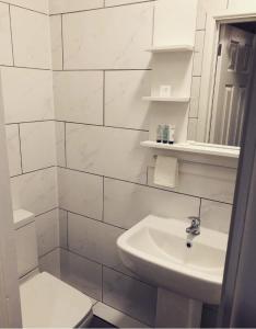 考文垂Bede Apartments的白色的浴室设有水槽和镜子
