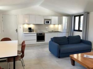 博尼法乔Les Appartements du Port的一间带蓝色沙发的客厅和一间厨房