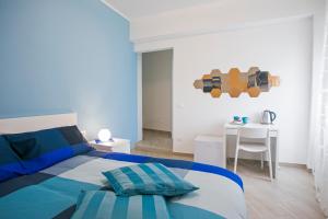 加埃塔B&B Sapore di Mare al Corso的一间蓝色和白色的卧室,配有一张床和一张桌子